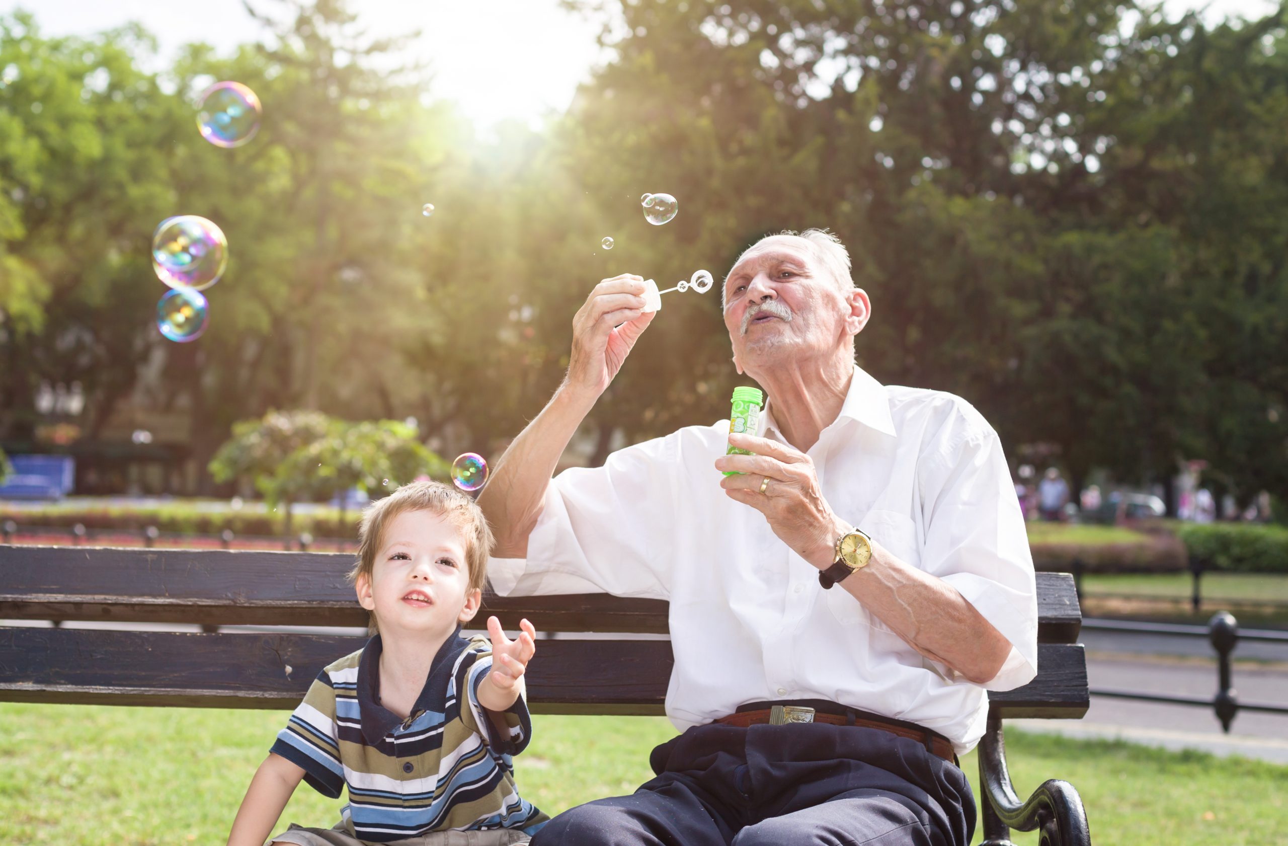 grandfather blowing bubbles for grandson